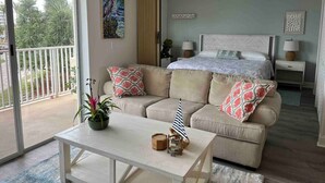 Una camera da letto con un letto, un divano, un tavolo e un balcone.