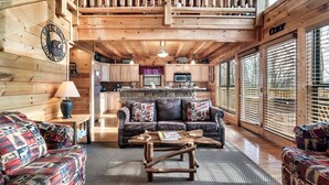 Ein gemütliches Blockhaus-Interieur mit Wohnbereich, Küche und Essbereich.