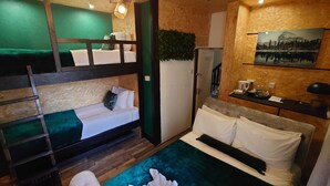 A room with bunk beds, a desk, a refrigerator, and a painting on the wall. - Harriette's Guest House (Blackpool)