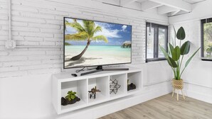 A white brick wall with a flat-screen TV displaying a beach scene. - Oasis by Sun Getaway Rentals Fort Lauderdale (Fort Lauderdale)