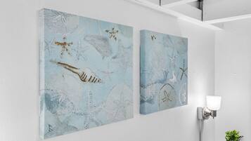Twee kunstwerken aan de muur met afbeeldingen van zeedieren.