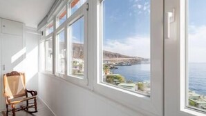 A room with large windows overlooking a coastal landscape. - Susurros of the sea Apartment (Candelaria)
