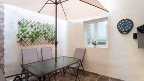 A dining area with a glass table and chairs, a ceiling fan, a window, and a dartboard on the wall. - Branmi House Big Ravine (Santa Cruz de Tenerife)