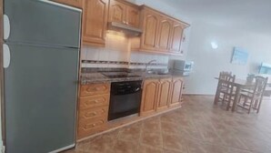 A kitchen with wooden cabinets, a refrigerator, and a tiled floor. - Sunset with views of Teide (Mesa del Mar)