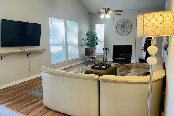 Living room w/ 55 in TV and wood burning fireplace. Gas starter.