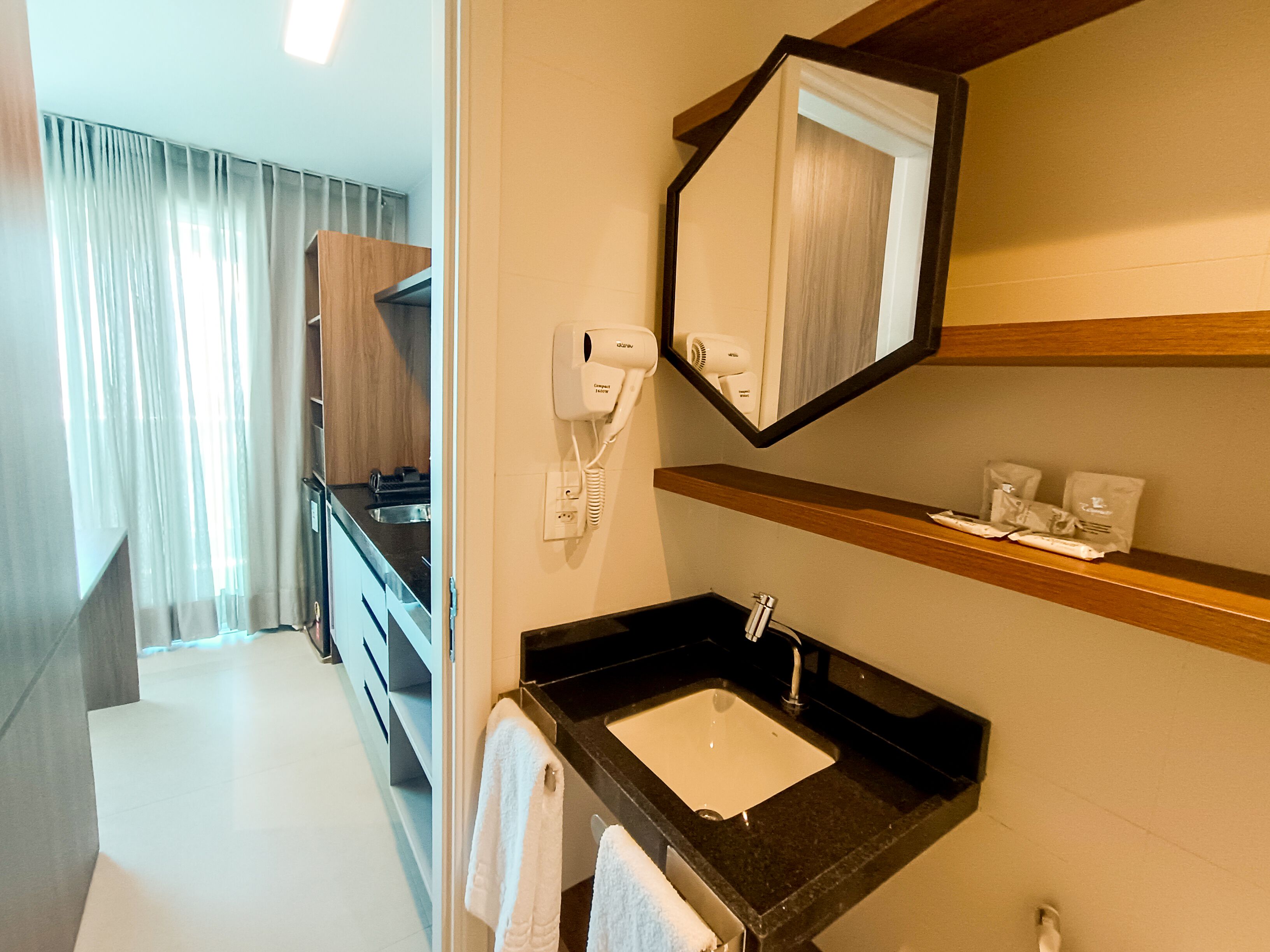 Une salle de bain d’hôtel avec un lavabo, un miroir et un porte-serviettes.