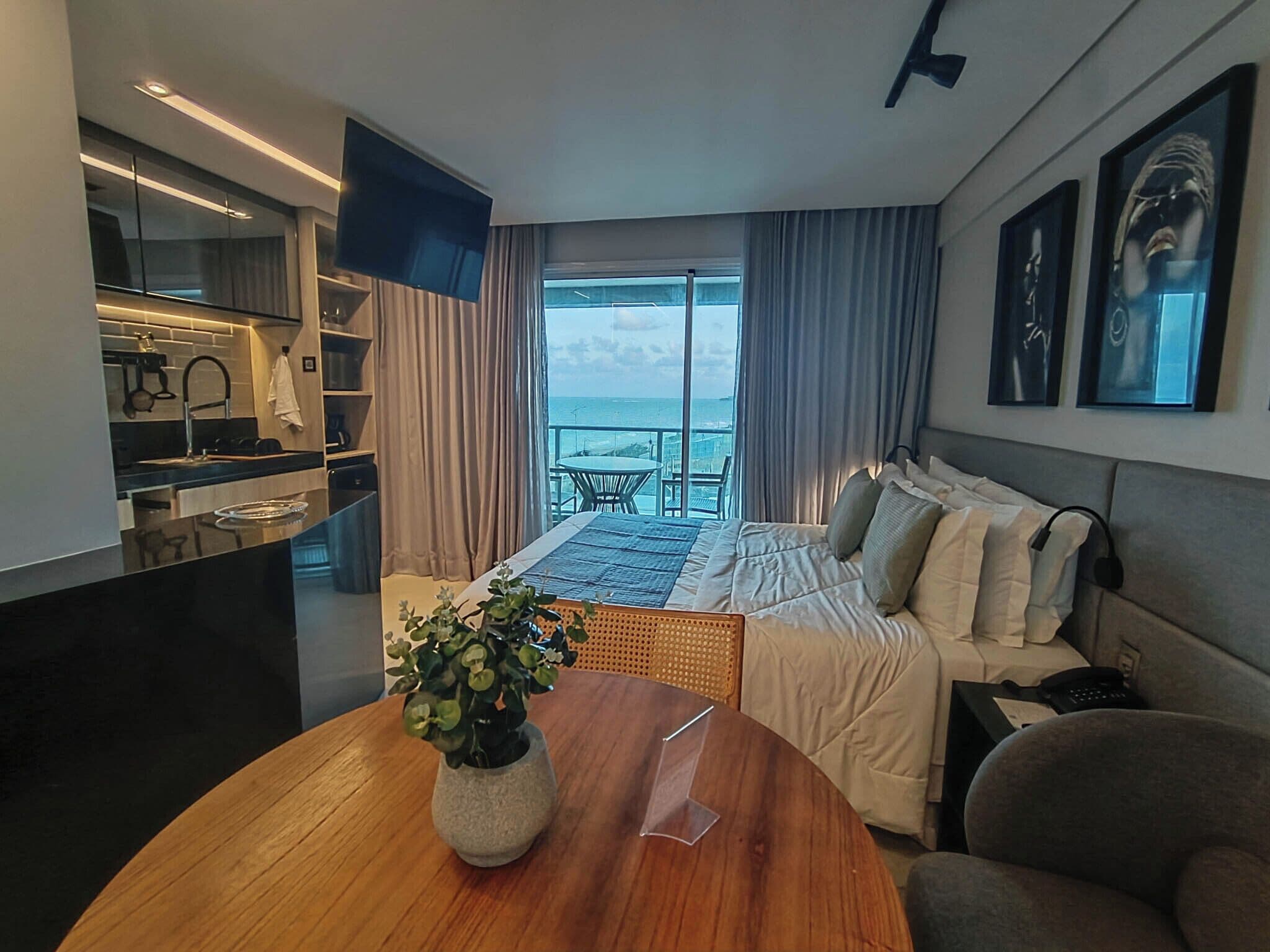 Une chambre d’hôtel moderne dotée d’un balcon, d’un lit, d’un bureau et d’une télévision.