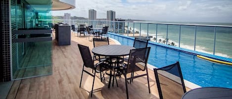 Una piscina al aire libre, sillones reclinables de piscina