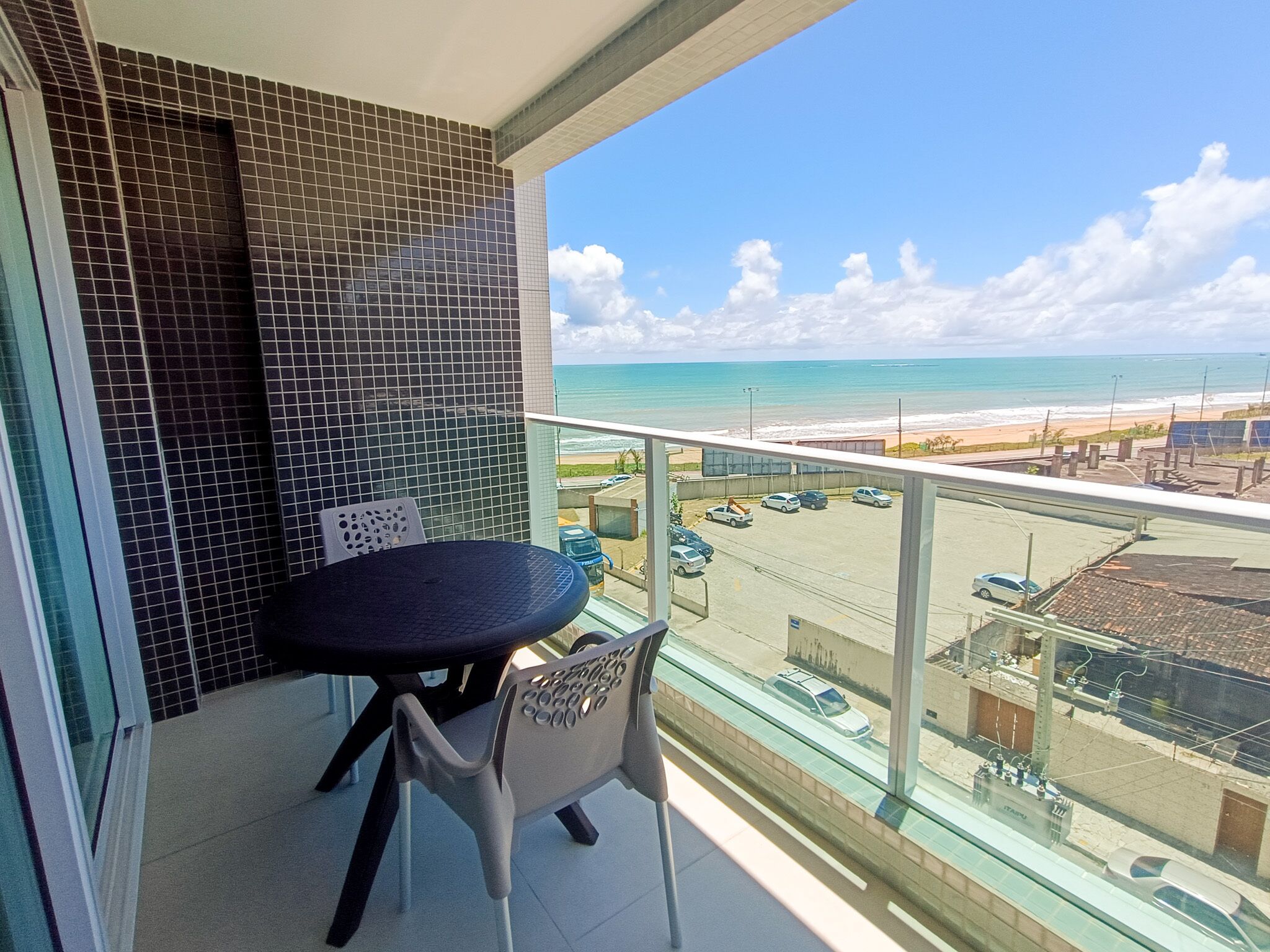 A balcony with a view of the beach and ocean.