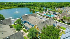 A residential area with a large lake, a swimming pool, and houses with sloped roofs. - Vilas em Seven Dwarfs - Orla1 (Kissimmee)