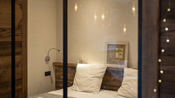 A modern bedroom with a large bed, bedside lamps, and a framed picture on the wall. - Top of the range flat with a large terrace in the heart of the village - sleeps 6 (ST SORLIN D ARVES)