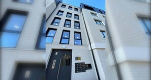 A modern building with a prominent entrance, multiple windows, and a visible sign. - Bright 1 BDR Flat Balcony Heart of Brixton (Brixton)