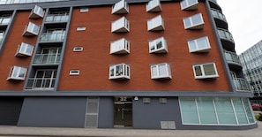 A multi-story building with a brick facade, multiple balconies, and a ground-level entrance. - Chic High-End 1BD Flat - Near Borough Market! (London)