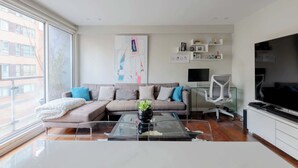 Uma sala de estar moderna com um sofá, mesa de centro e televisão.