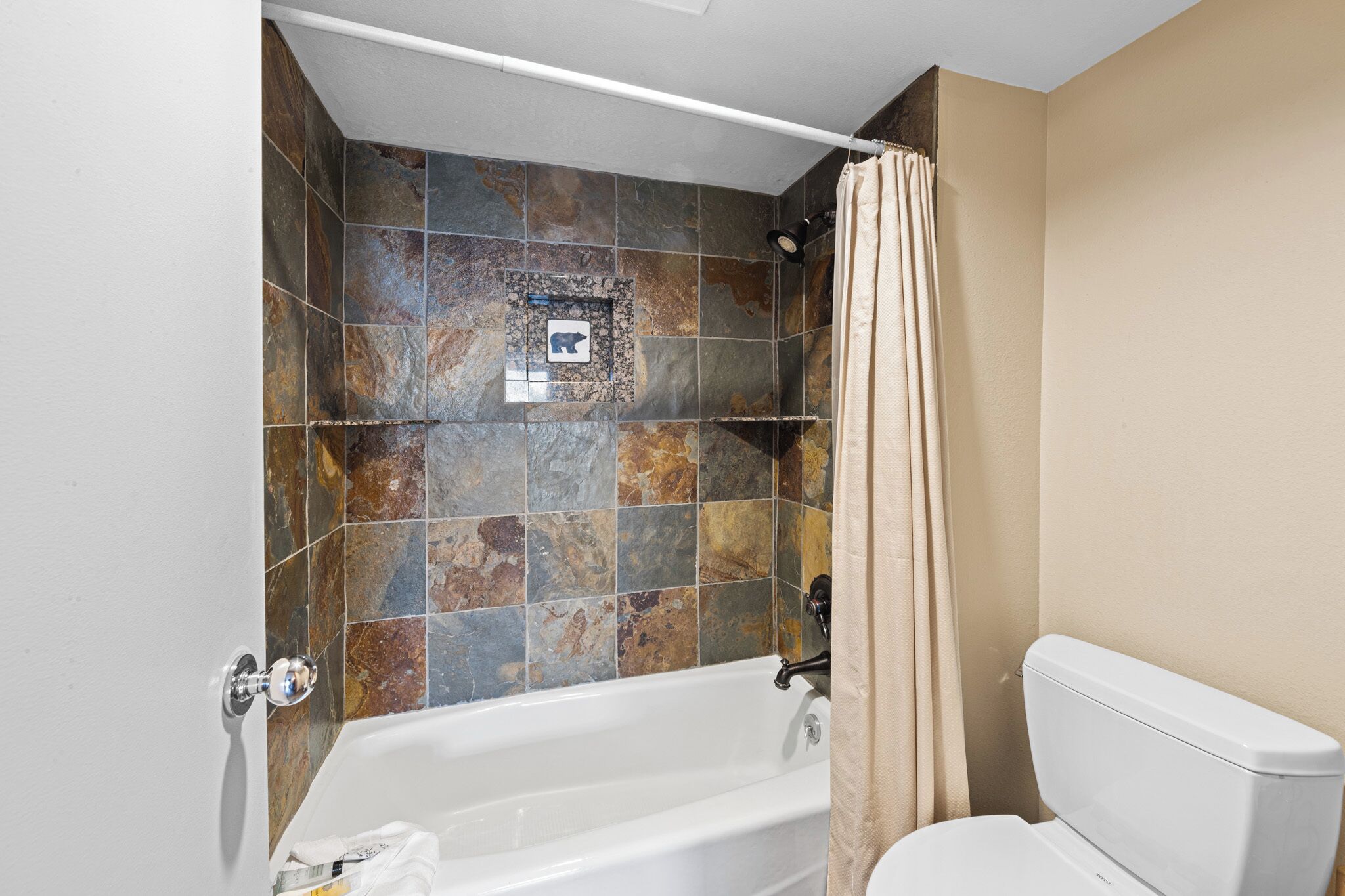 A bathroom with a bathtub, shower, and toilet.