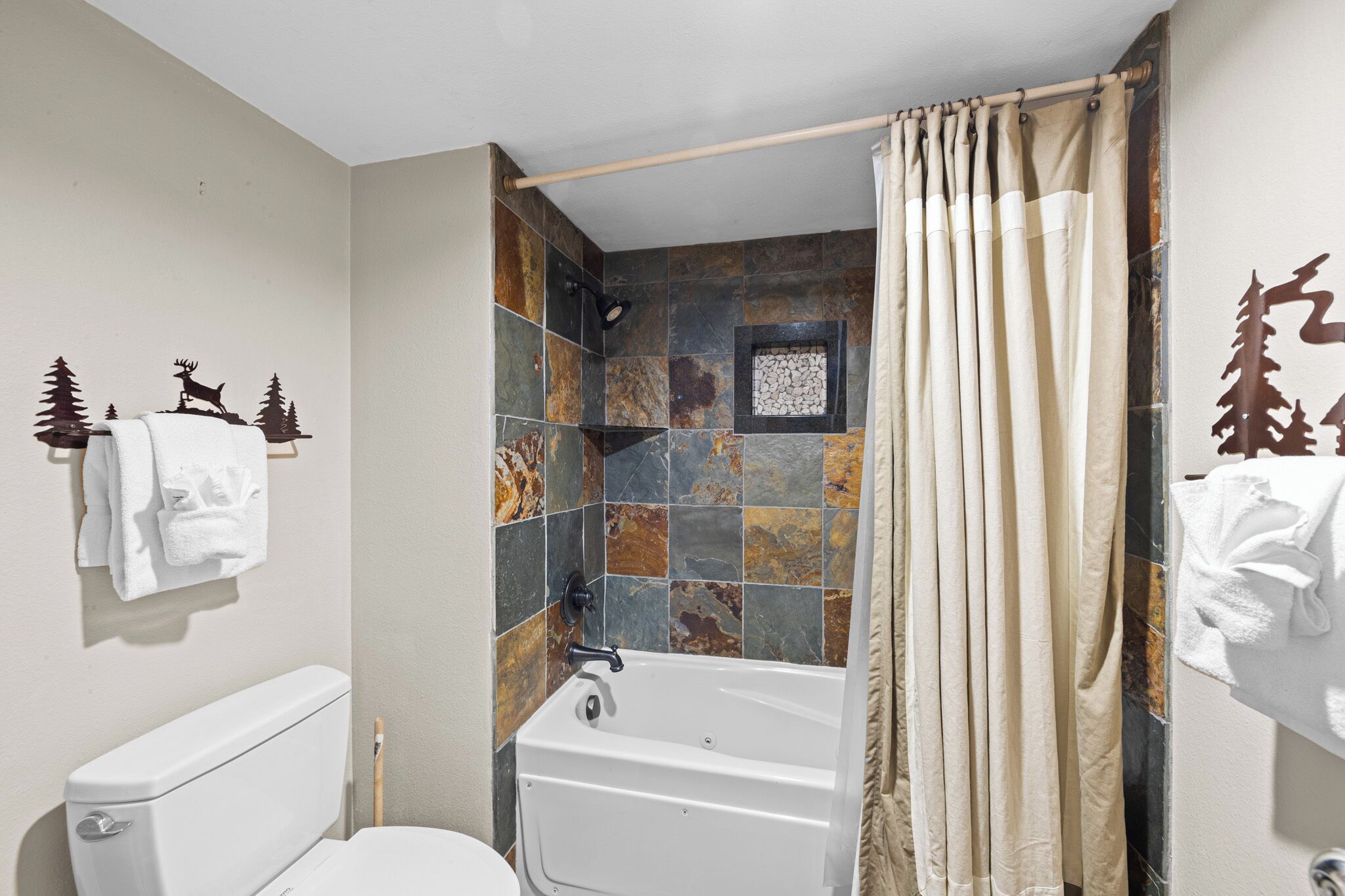 A bathroom with a toilet, bathtub, and shower curtain.