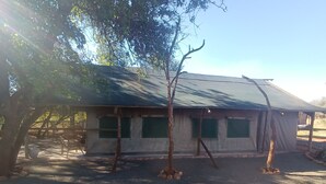 A single-story building with a sloped roof, surrounded by trees.
