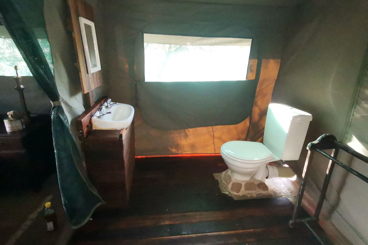 Un baño pequeño con lavamanos, inodoro y una ventana para luz natural.