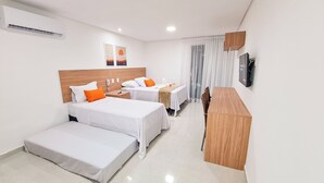 A hotel room with two beds, a desk, a TV, and a window with curtains. - Sunset by AFT - Porto de Galinhas (Ipojuca)