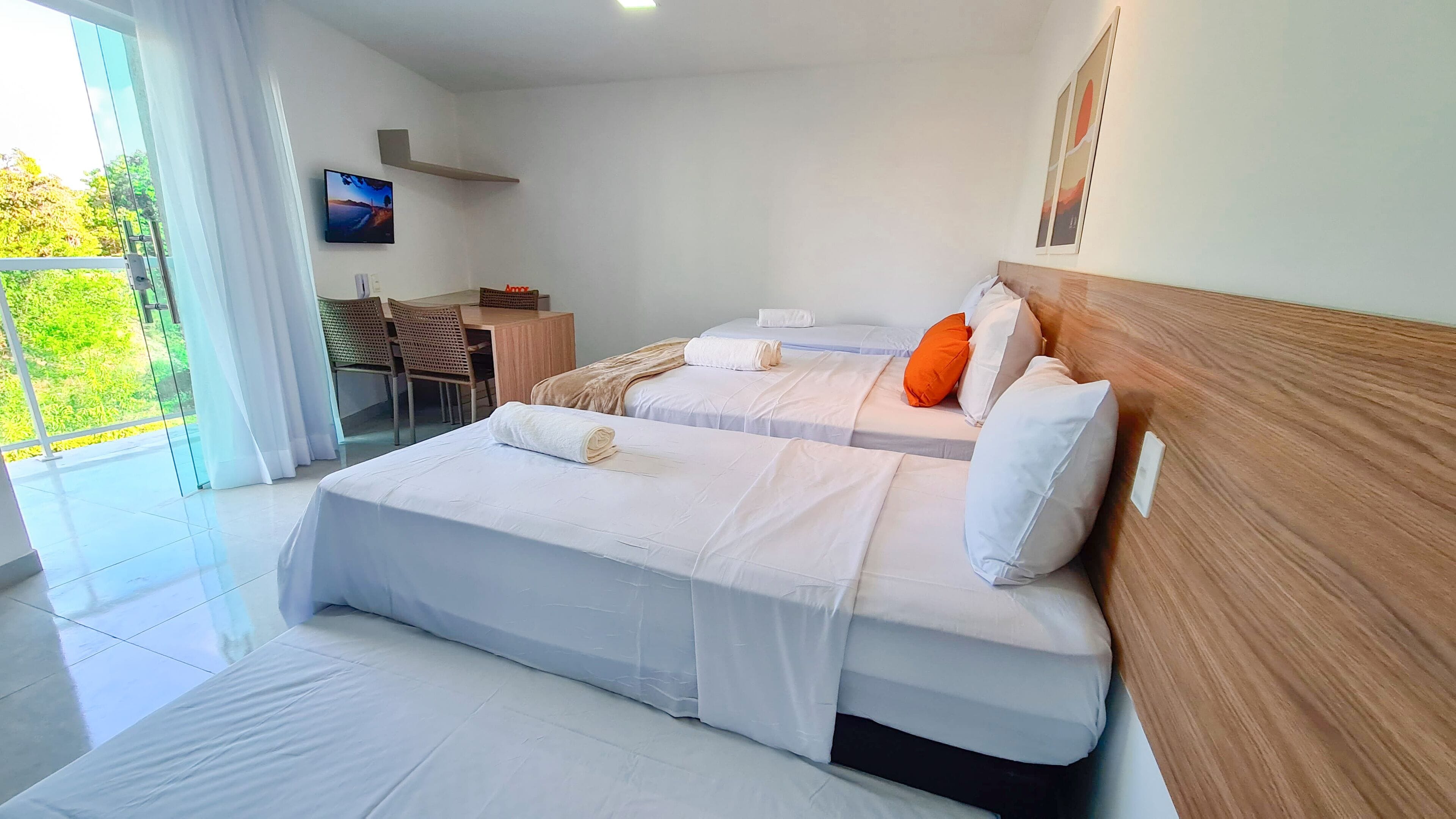 Ein modernes Hotelzimmer mit einem großen Bett, einem Schreibtisch und Blick auf grüne Natur.