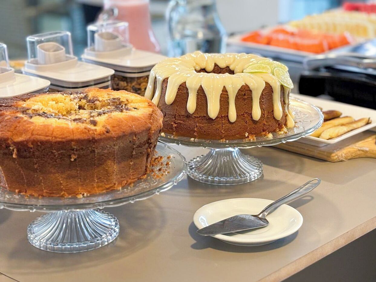 A buffet table with various desserts including a bundt cake and a cake with white icing.