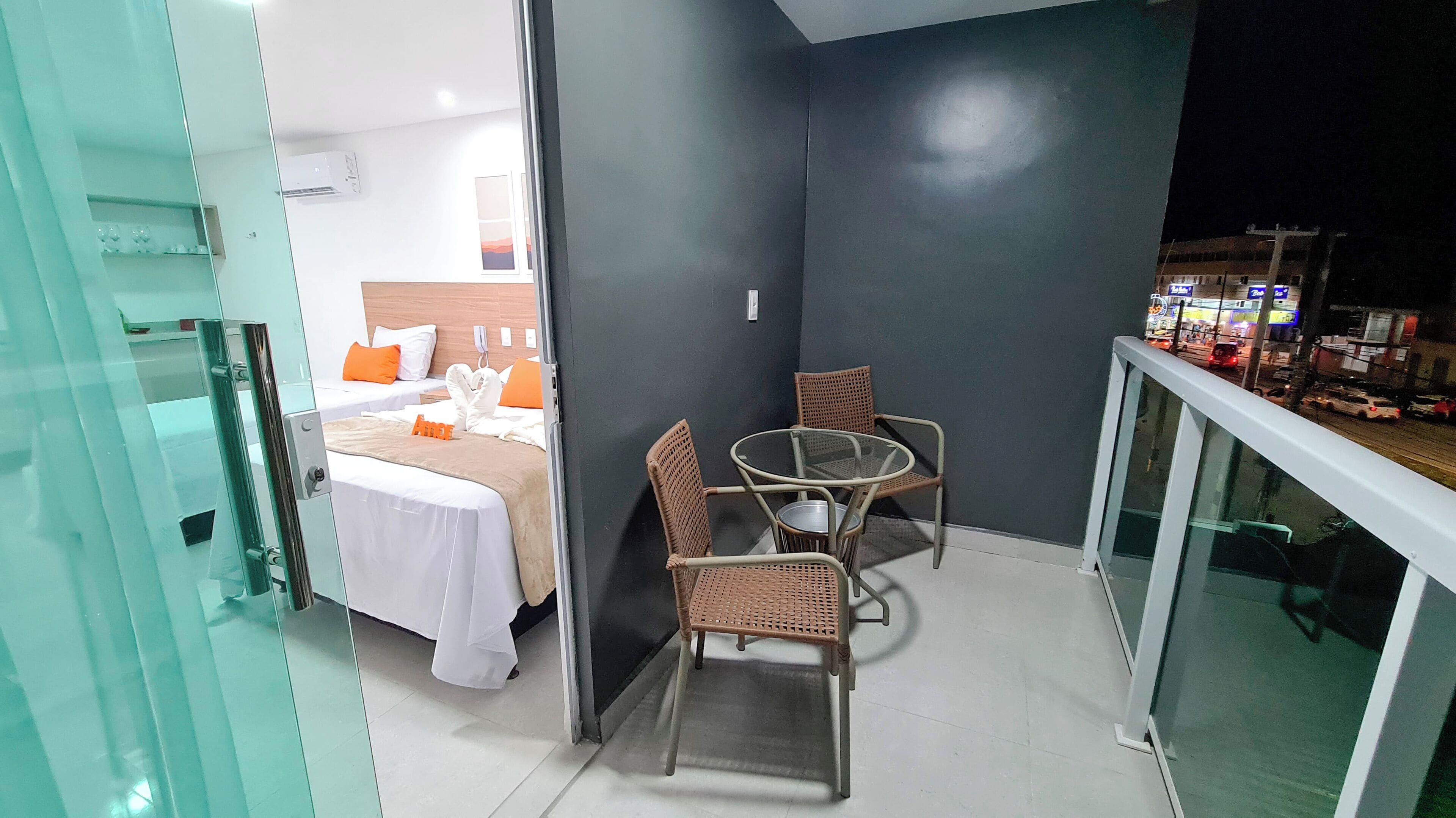 A balcony with a bed, a table, and chairs.