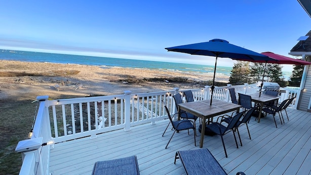 Eine Terrasse mit Gartenmöbeln und Blick auf den Strand.