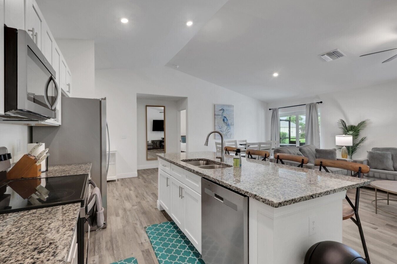 Een moderne keuken met een centraal eiland, inbouwapparatuur en een eetgedeelte met uitzicht.