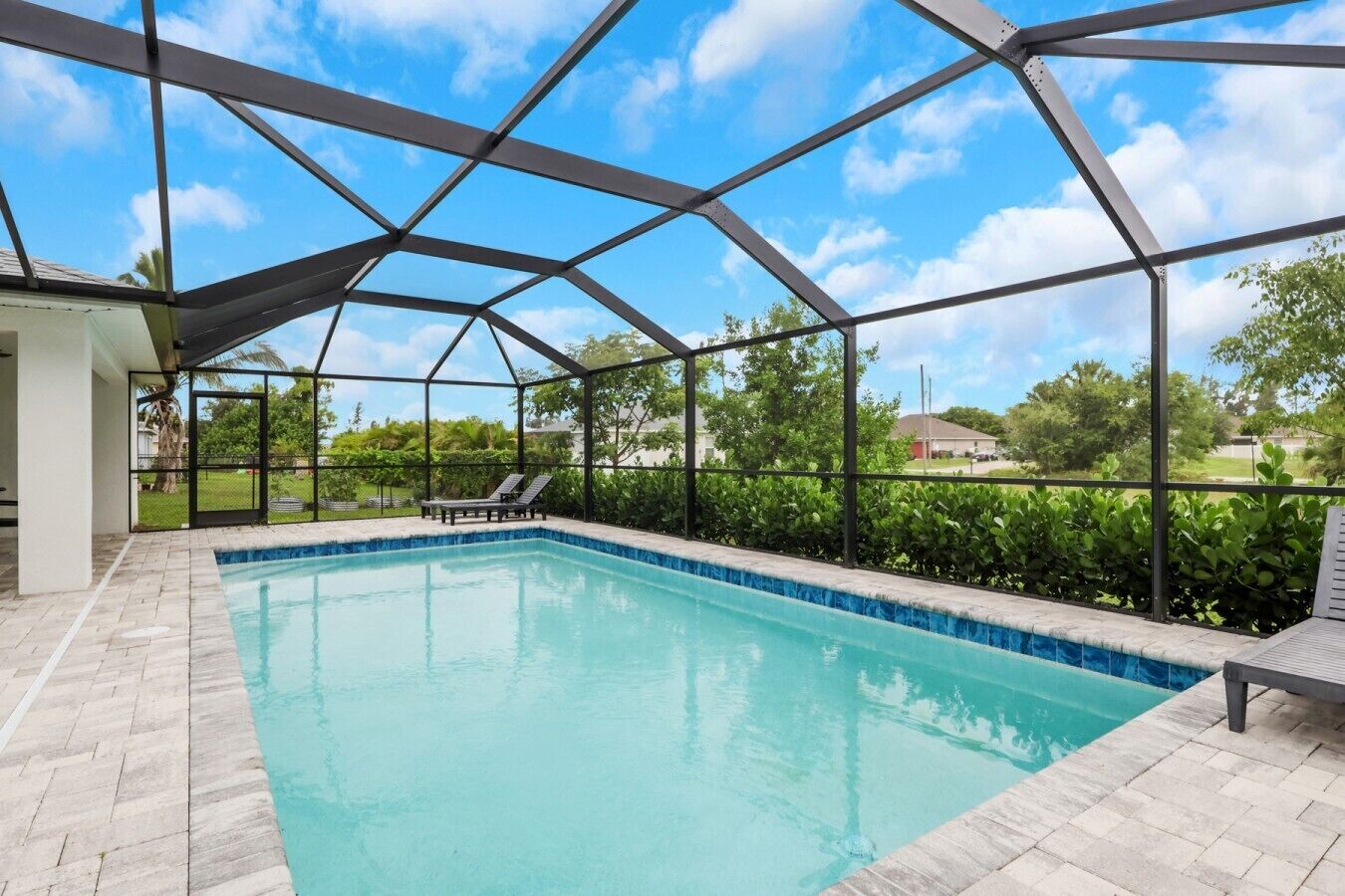 Une piscine intérieure offrant une vue dégagée sur le ciel et la végétation environnante.