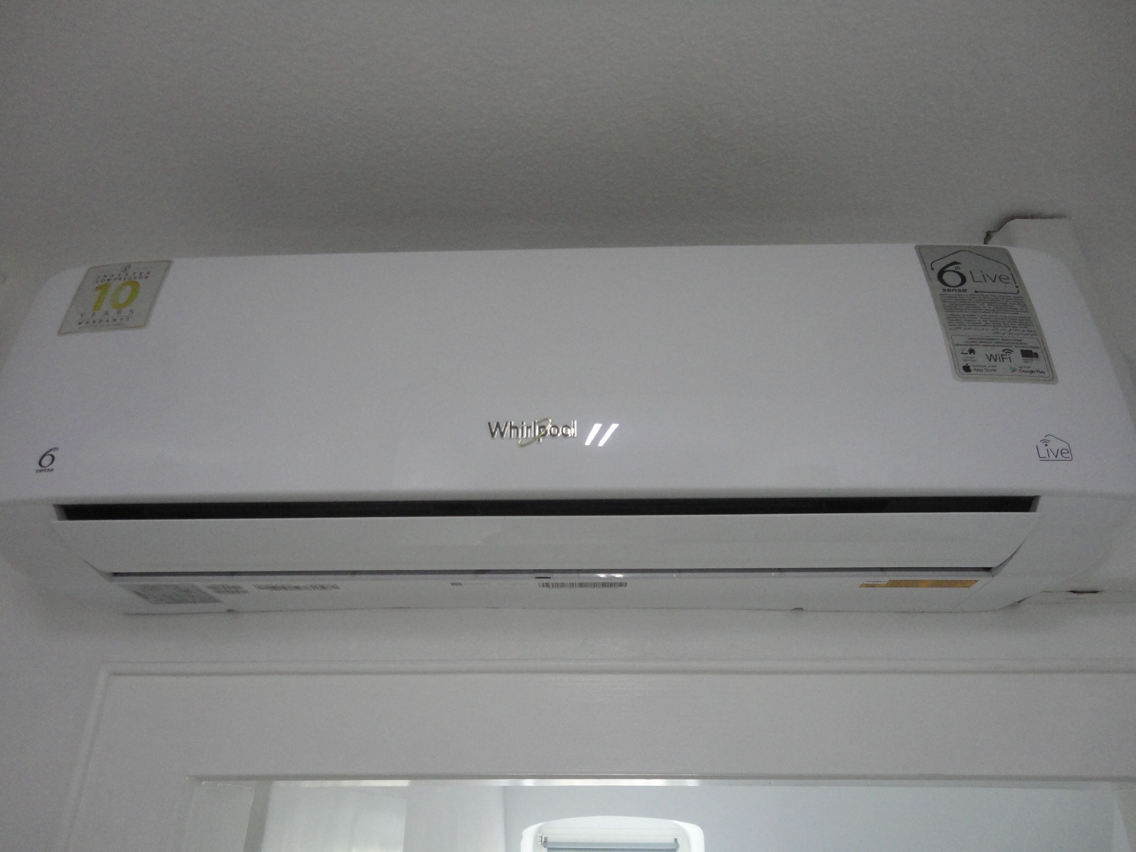 A white Whirlpool air conditioner unit with a 6 Live logo, a 10 years warranty sticker, and a WiFi symbol.