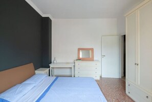 A bedroom with a bed, a desk, a dresser, and a wardrobe. - In the heart of Monteverde (Roma)