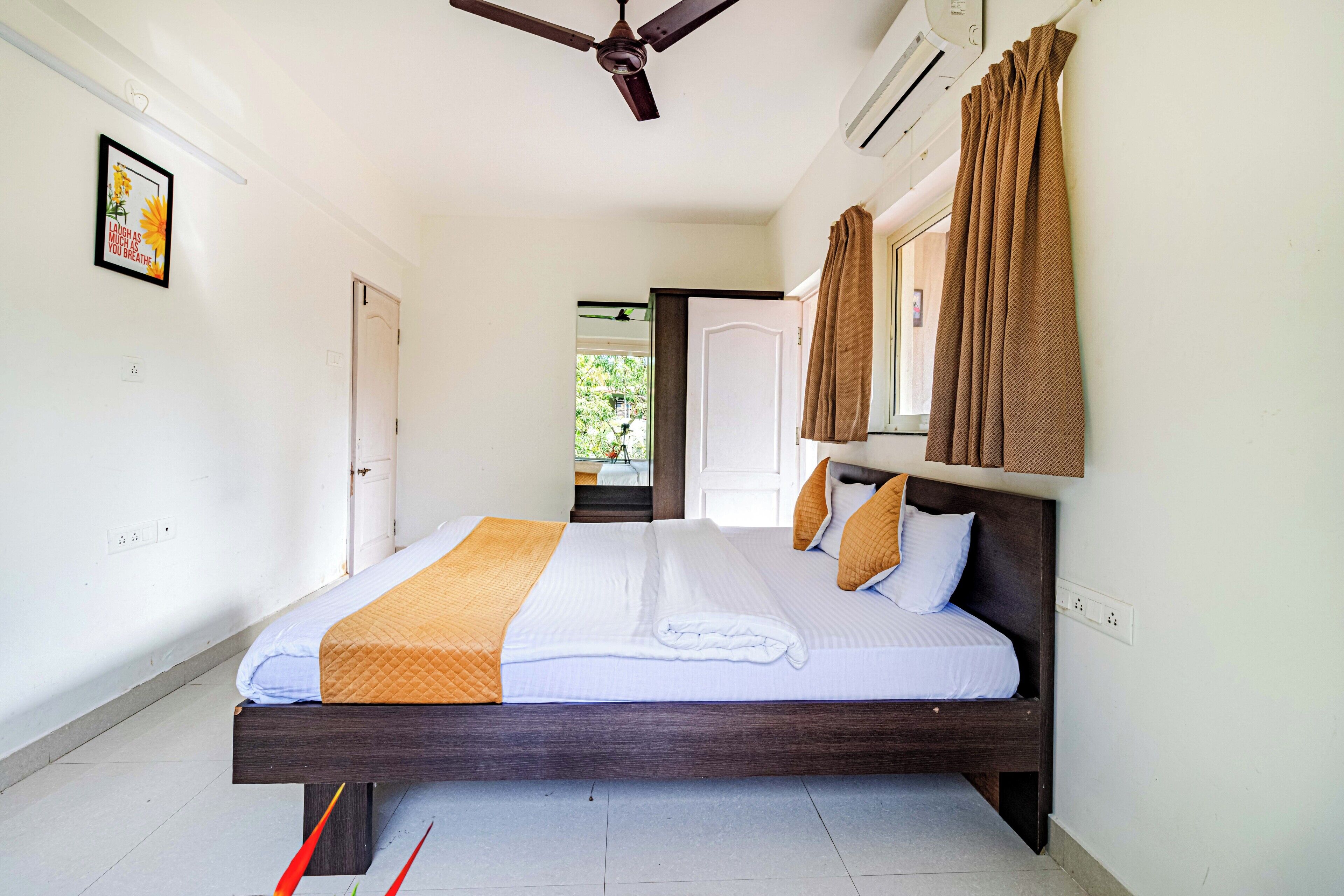 A bedroom with a bed, a ceiling fan, an air conditioning unit, and a view of the outdoors.