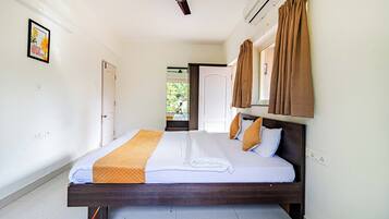 A bedroom with a bed, a ceiling fan, an air conditioning unit, and a view of the outdoors.