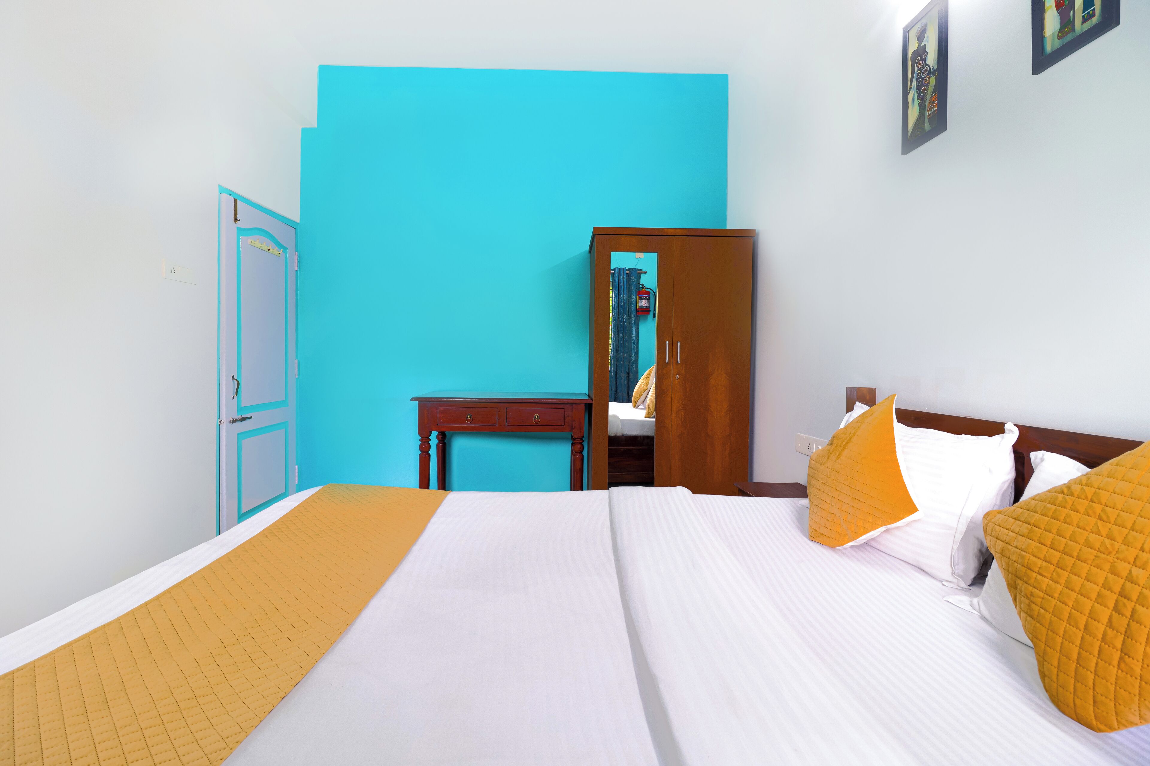 A hotel room with a bed, a desk, a chair, and a wardrobe.