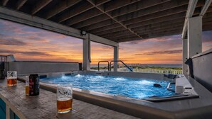 Bar no terraço com hidromassagem, com vista para o pôr do sol.