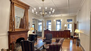 A spacious lobby with a grand chandelier, a fireplace, and a reception desk. - The Brandon Inn - Single Room (Brandon)