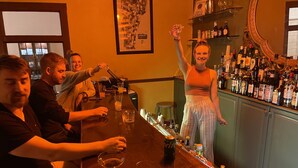A bar area with a wooden counter, various bottles, glasses, and a map on the wall. - The Brandon Inn - Single Room (Brandon)