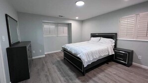 Une chambre à coucher avec un lit, une commode et des tables de chevet.