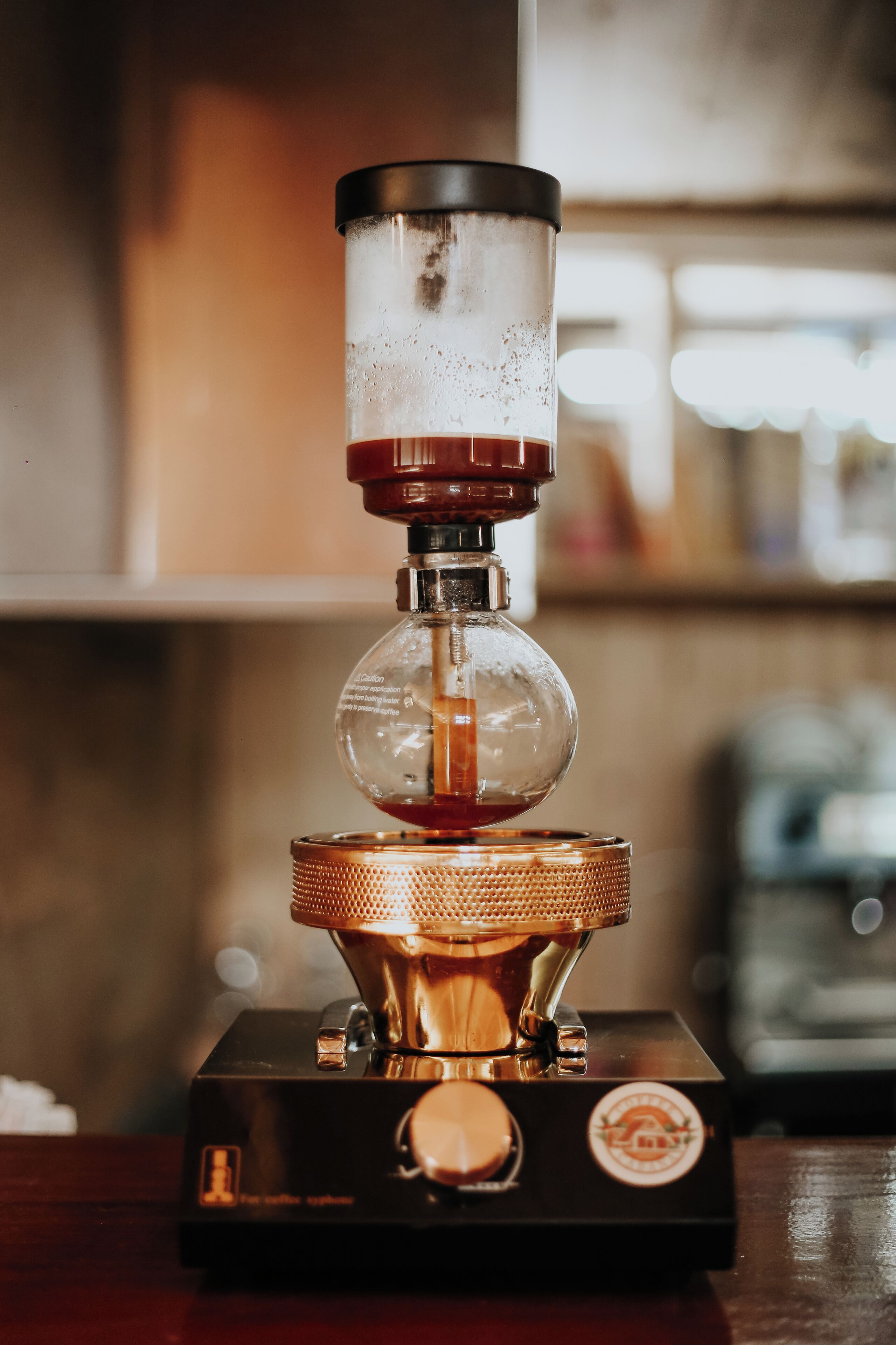 Eine Kaffeemühle mit transparentem Behälter und metallischem Fuß.