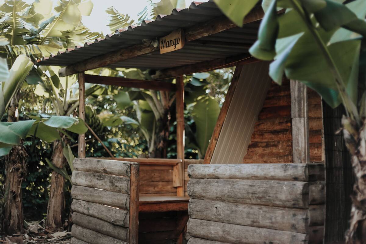 Une structure rustique en bois, sur laquelle est apposée une enseigne indiquant « Mangue ».