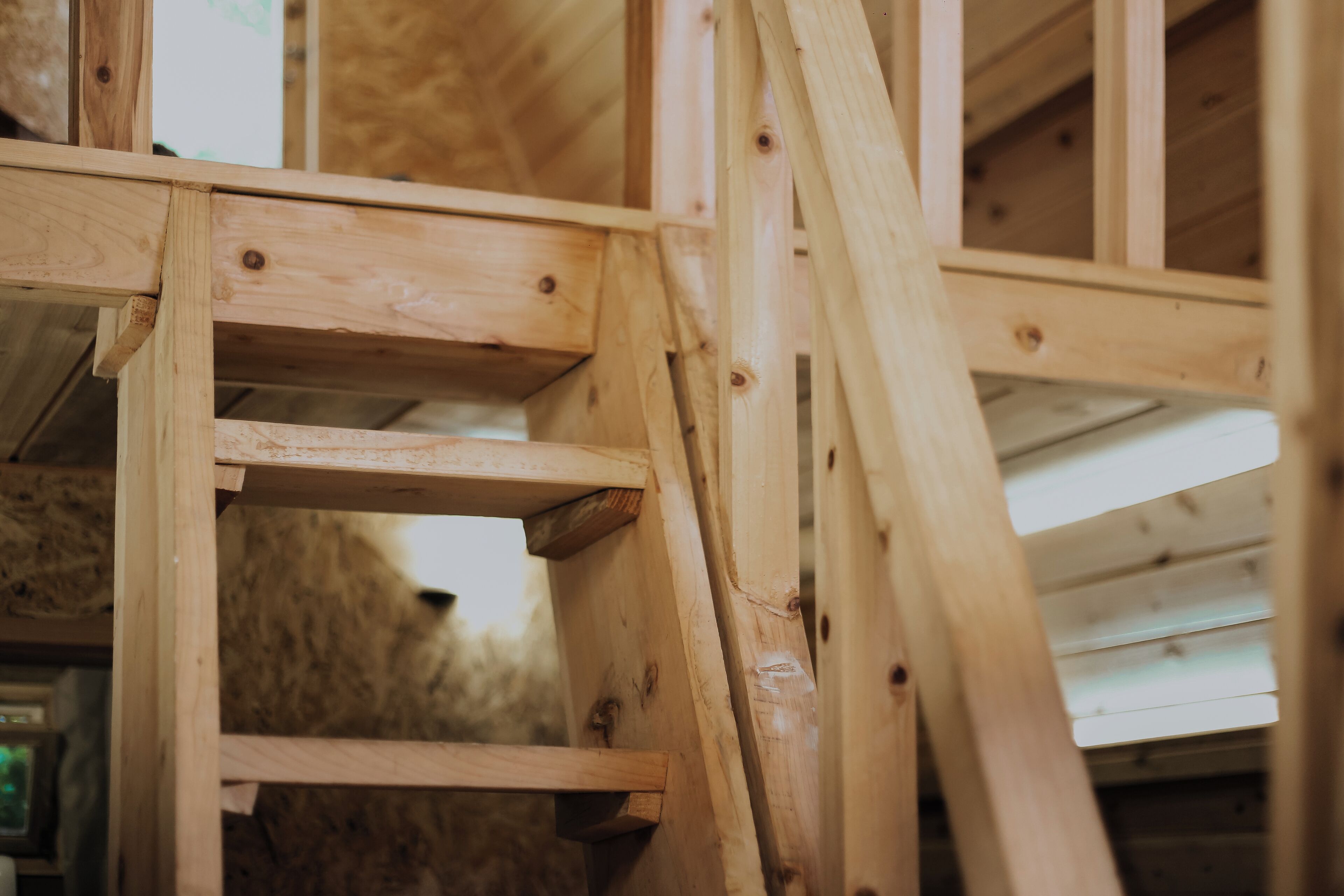 Un escalier en bois, doté d’une rampe et de marches, menant à l’étage supérieur.