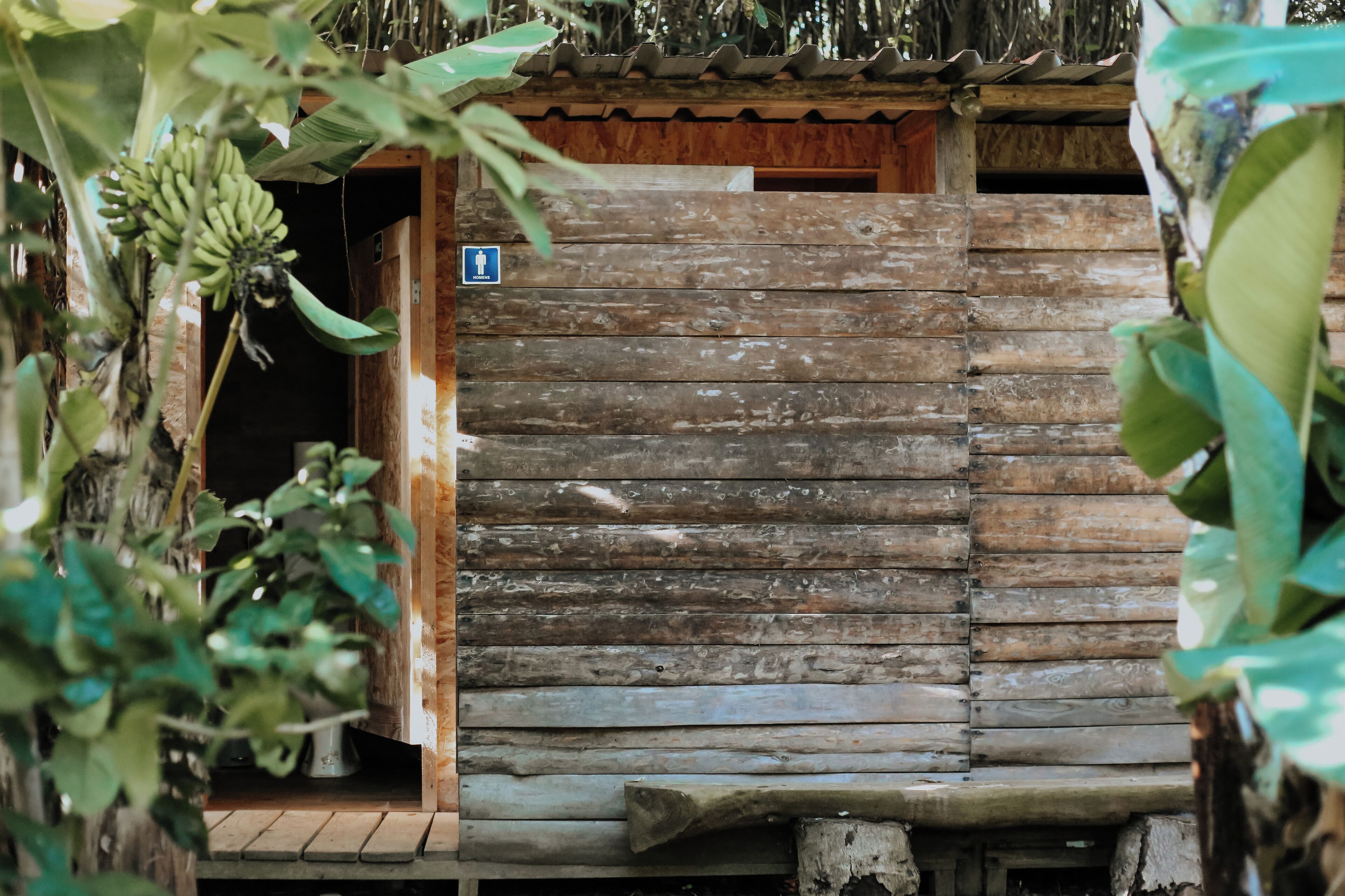A rustic wooden building with a door and a small sign.
