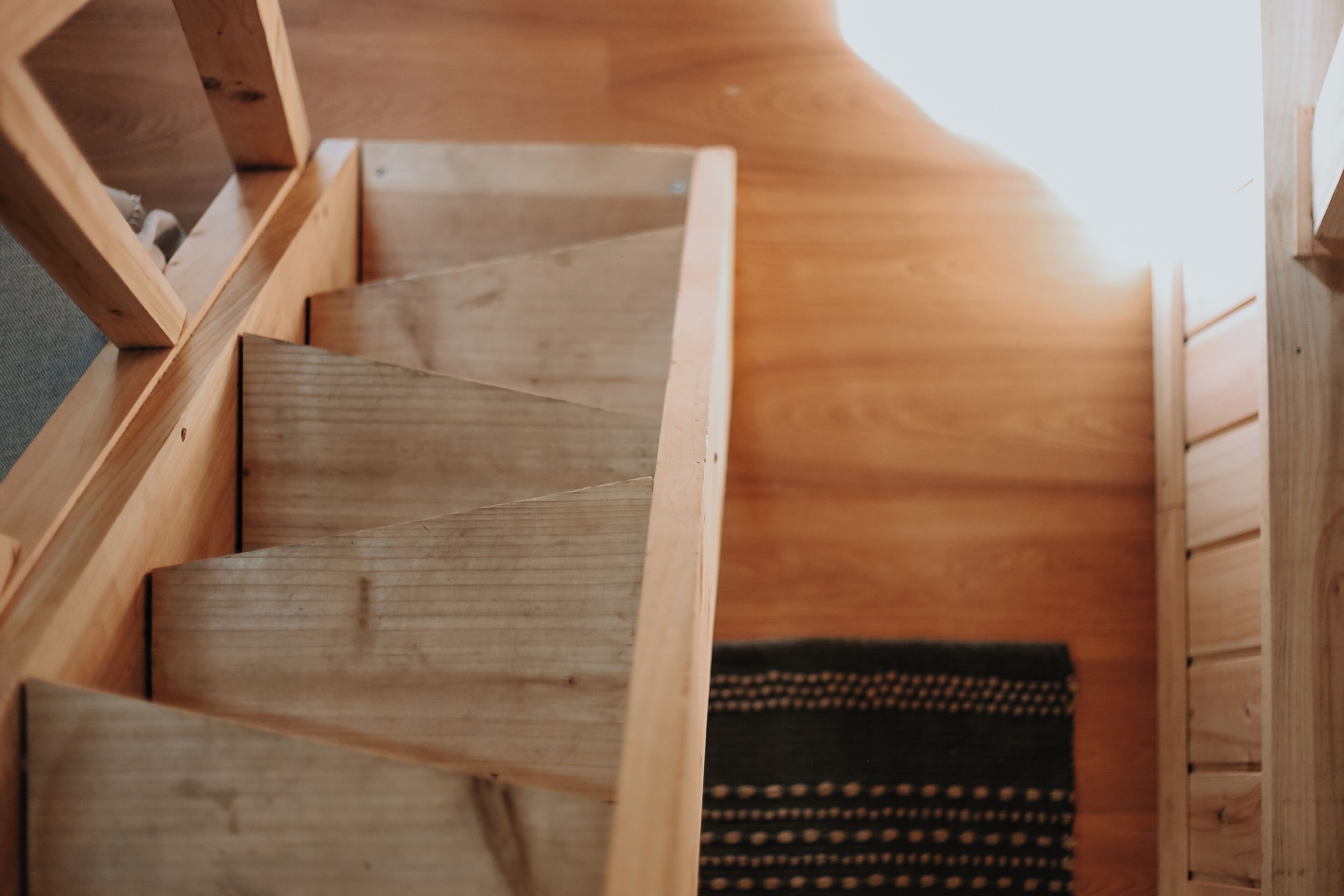 Una escalera de madera con un diseño curvo que conduce a un nivel inferior.