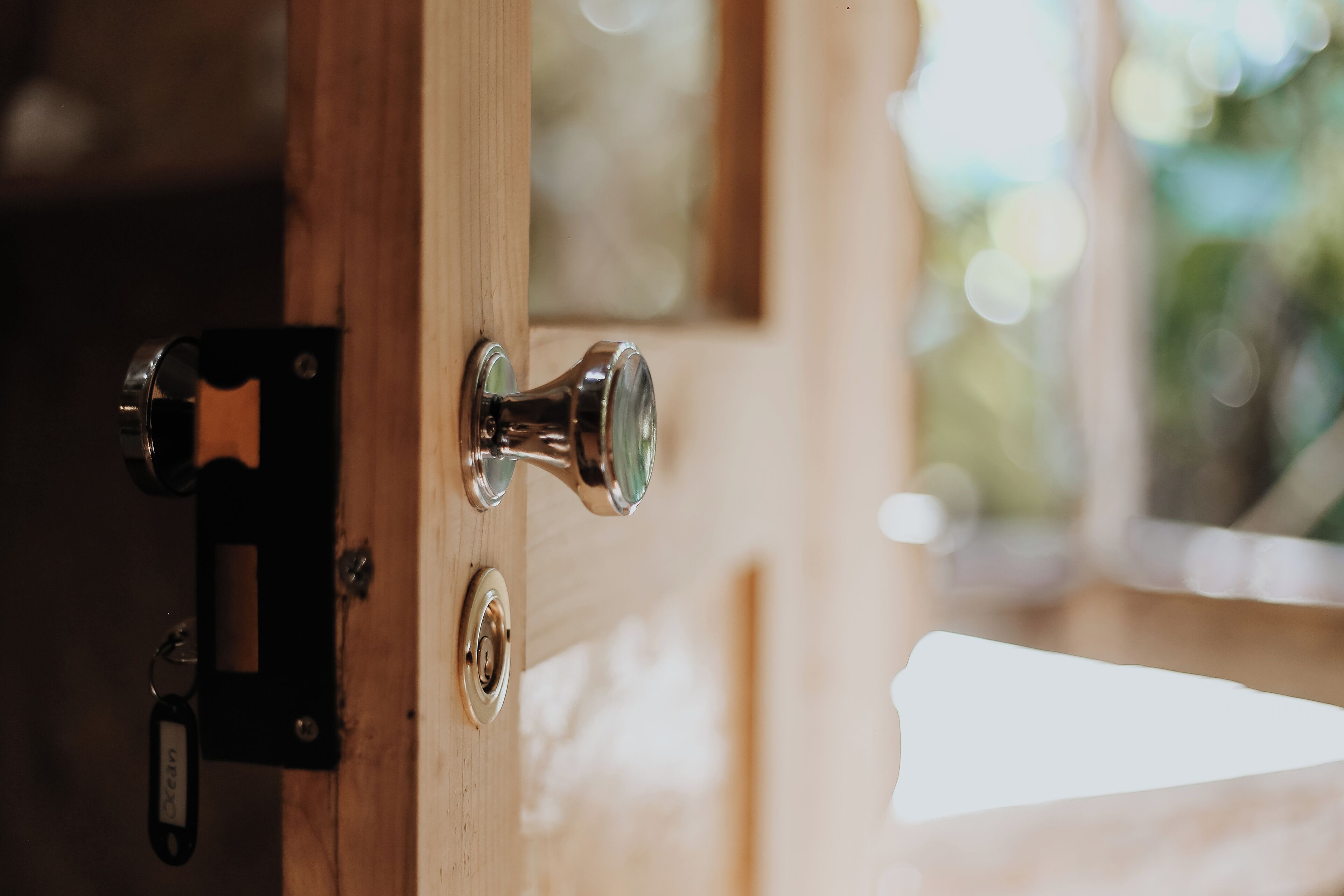A wooden door with a silver handle and a keyhole.