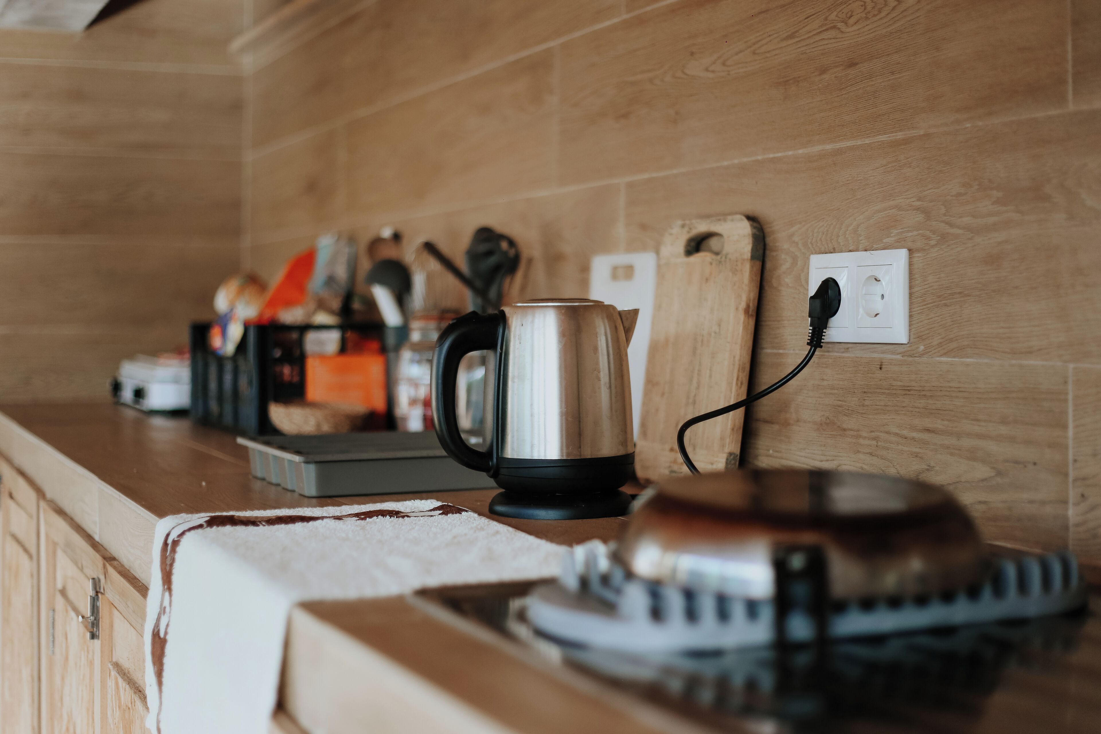 Un piano di lavoro in cucina con un bollitore, un tostapane e una macchina per il caffè collegati.