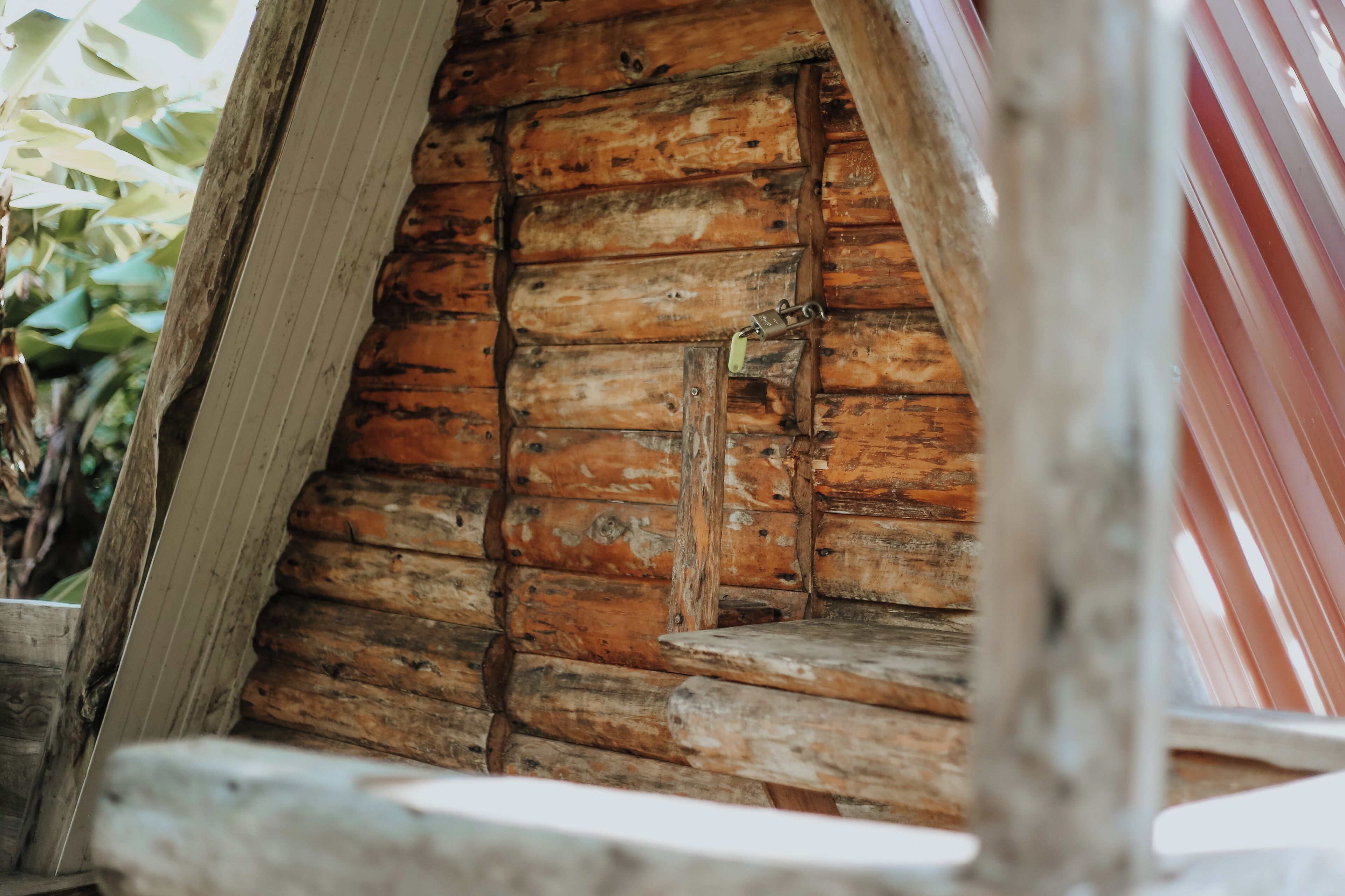 A rustic wooden cabin interior with a wooden door and a small window.