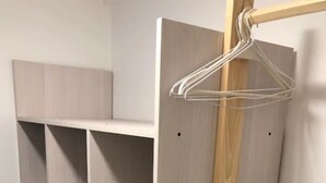 Ein Schrank mit mehreren Regalen und einer Kleiderstange.