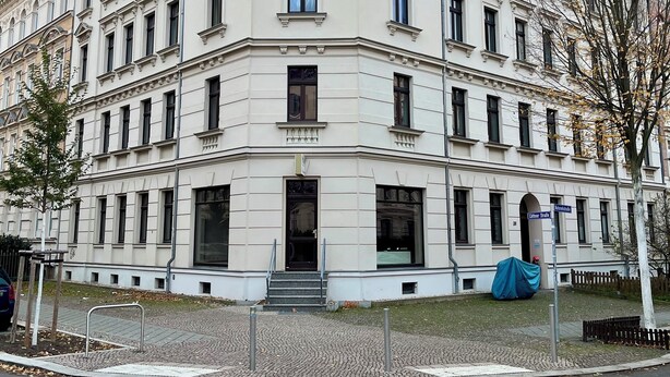 A multi-story building with a classical architectural style, featuring a symmetrical facade, large windows, and a central entrance with steps. - Stillvolles 3R Apartment mit Balkon (Leipzig)