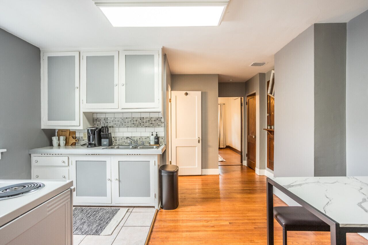 A modern kitchen with white cabinets, a tiled backsplash, and a central island.