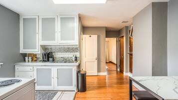 A modern kitchen with white cabinets, a tiled backsplash, and a central island.